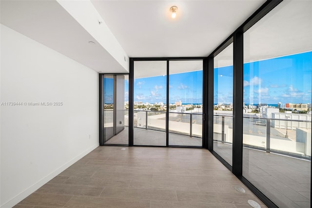 empty room featuring expansive windows and hardwood / wood-style floors