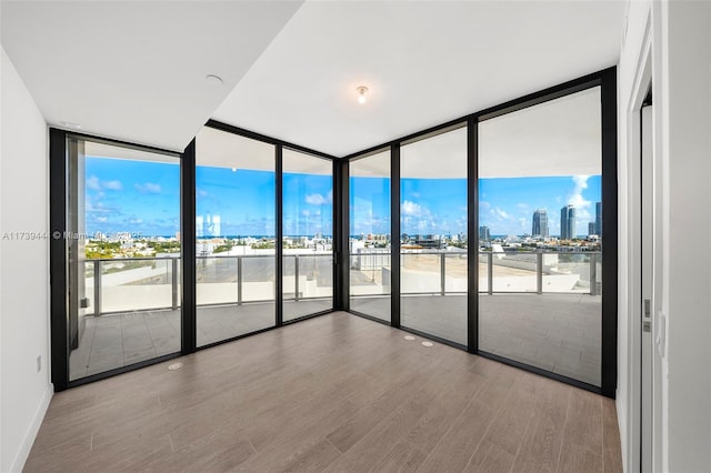 unfurnished room featuring hardwood / wood-style floors and expansive windows