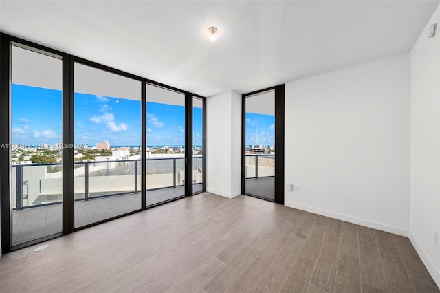 empty room with hardwood / wood-style floors and floor to ceiling windows