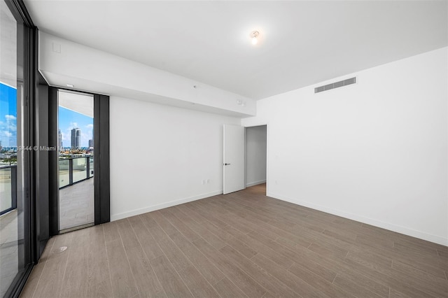 spare room with hardwood / wood-style flooring and floor to ceiling windows