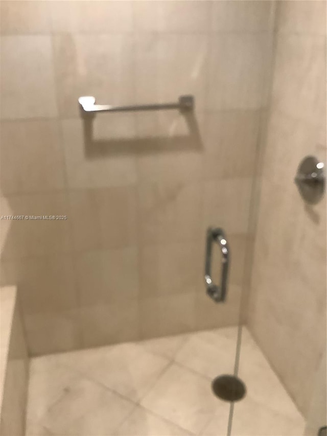 bathroom featuring a shower with door and tile patterned flooring