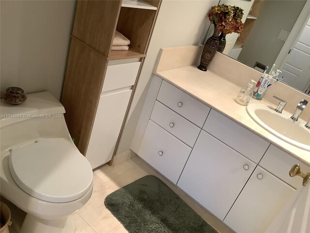 bathroom featuring vanity, tile patterned floors, and toilet