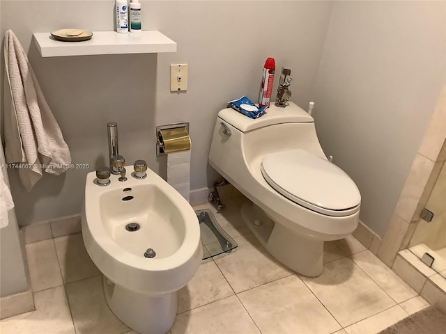 bathroom with a bidet, toilet, and tile patterned flooring