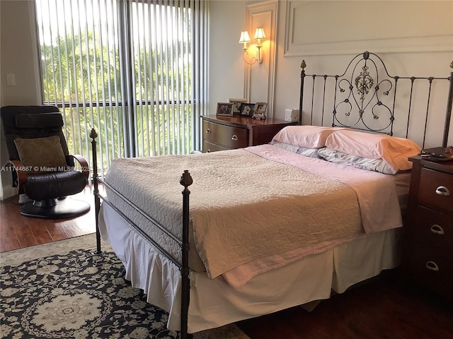 bedroom with access to exterior and hardwood / wood-style flooring