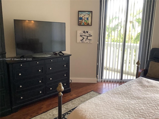 bedroom featuring access to exterior and dark wood-type flooring