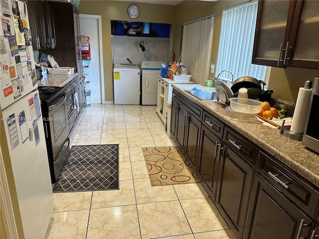 kitchen with sink, stainless steel electric range, dark brown cabinets, washer and dryer, and white fridge