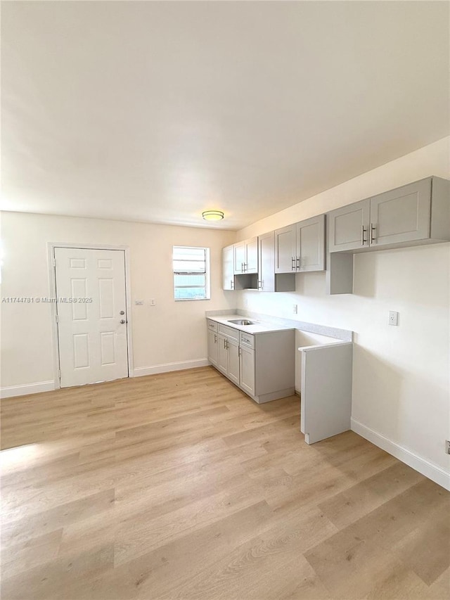 kitchen featuring sink, gray cabinets, and light hardwood / wood-style floors