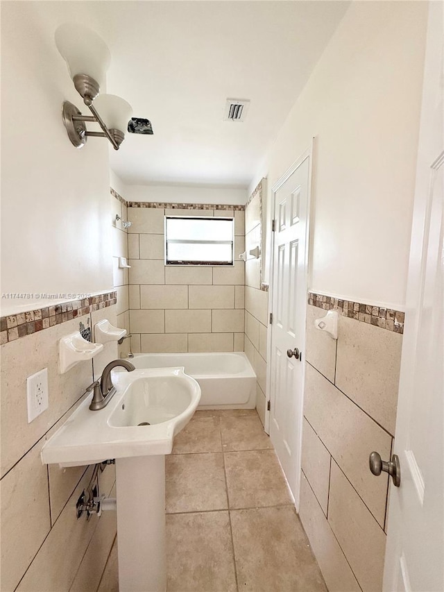 bathroom with tiled shower / bath combo, tile walls, and tile patterned floors