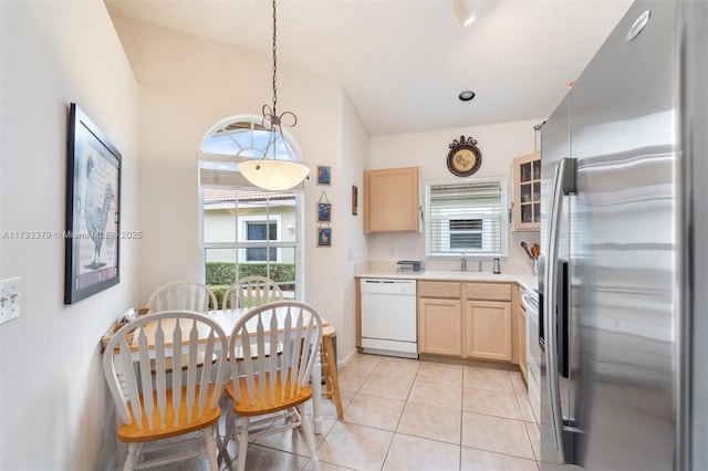 kitchen with stainless steel refrigerator, white dishwasher, light tile patterned flooring, decorative light fixtures, and light brown cabinets