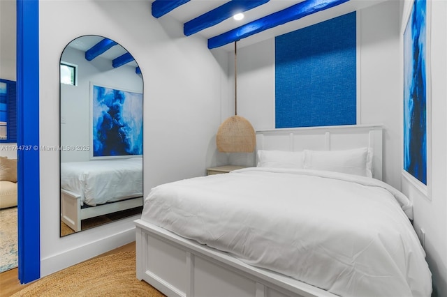 bedroom featuring beam ceiling and light wood-type flooring