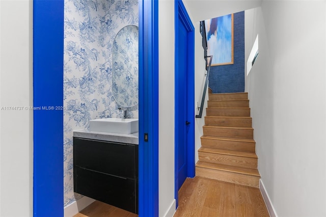 stairway featuring sink and hardwood / wood-style floors