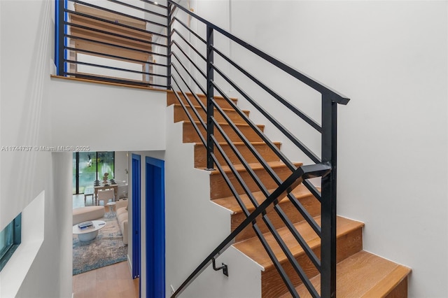 stairs featuring a high ceiling and hardwood / wood-style floors