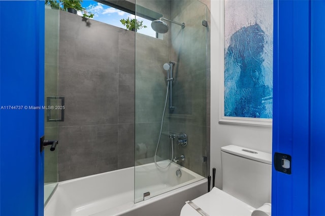 bathroom with tiled shower / bath combo and toilet