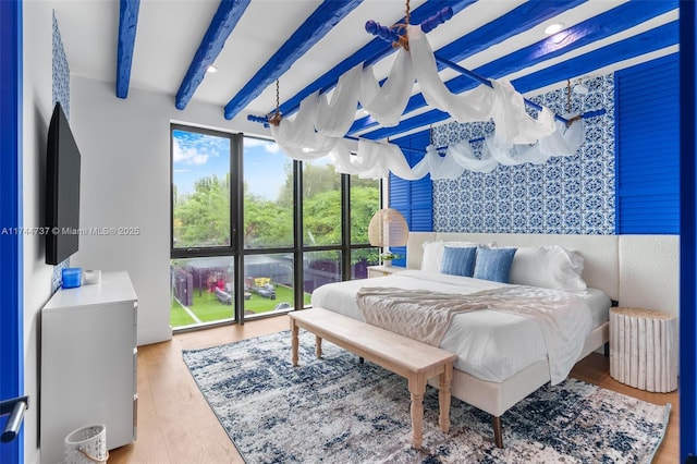 bedroom featuring hardwood / wood-style flooring, radiator heating unit, and beamed ceiling