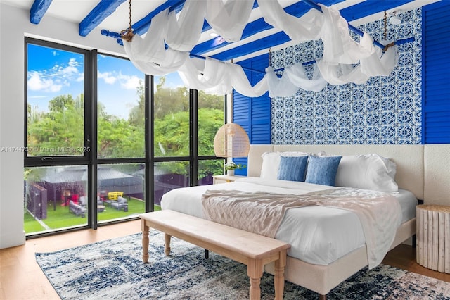 bedroom featuring beam ceiling, radiator, and hardwood / wood-style floors