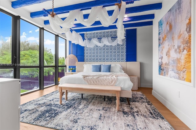 bedroom featuring hardwood / wood-style flooring and beam ceiling