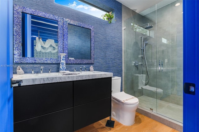 bathroom with toilet, wood-type flooring, vanity, and walk in shower