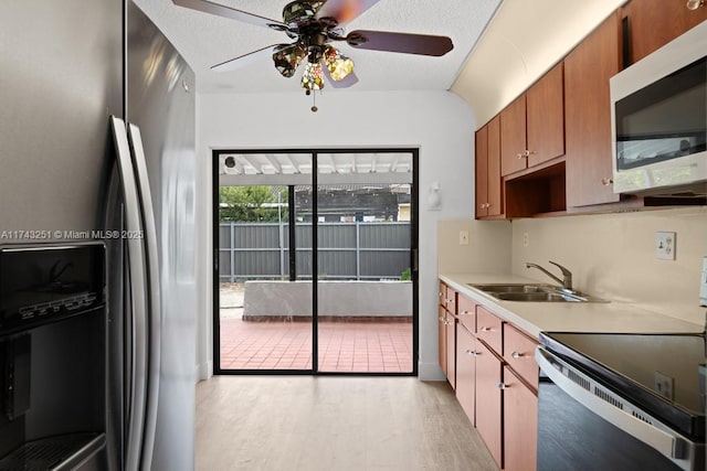 kitchen with stainless steel appliances, ceiling fan, sink, and light wood-type flooring