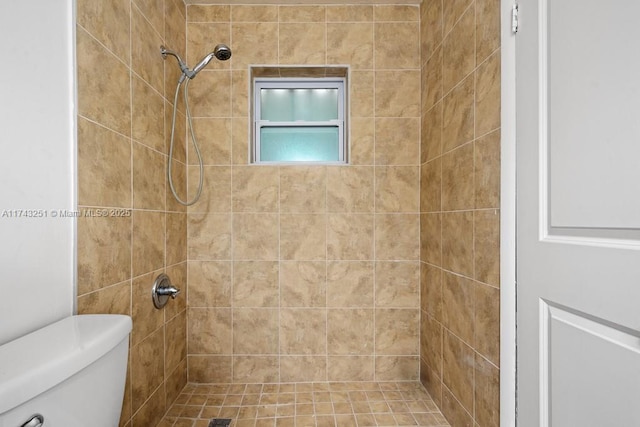 bathroom featuring toilet and tiled shower