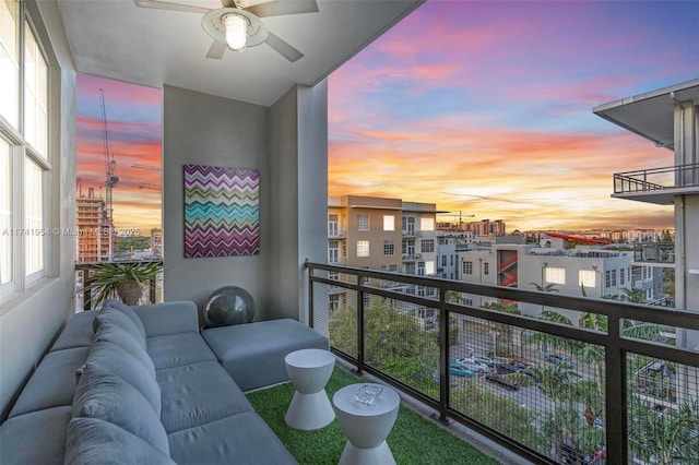 balcony at dusk featuring ceiling fan