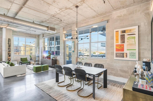 dining area with concrete flooring and a chandelier