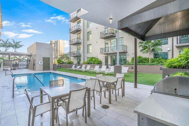 view of swimming pool with an outdoor kitchen, grilling area, and a patio area