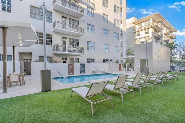 view of swimming pool featuring a yard and a patio area