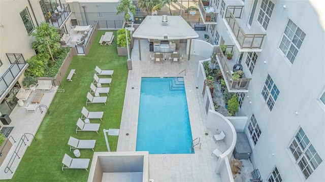 view of pool with a patio area and a lawn