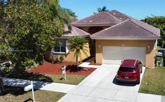 575 SE 29th Dr, Homestead, FL 33033 - view of front facade featuring a garage, stucco siding, a tiled roof, and concrete driveway