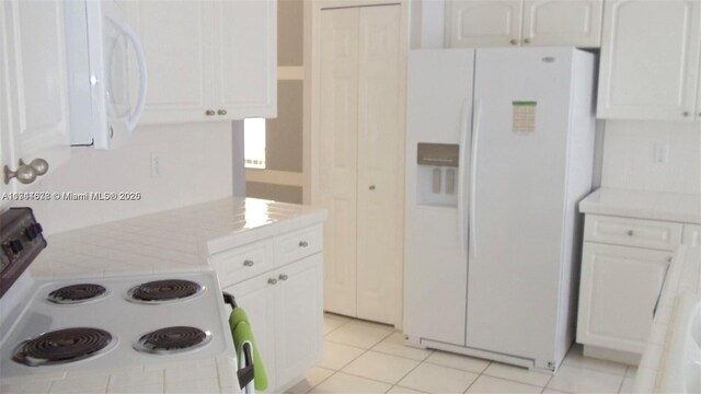 575 SE 29th Dr, Homestead, FL 33033 - kitchen with white appliances, tile counters, white cabinetry, and light tile patterned floors