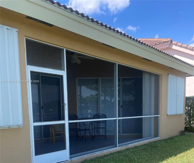 view of home's exterior featuring a sunroom and stucco siding