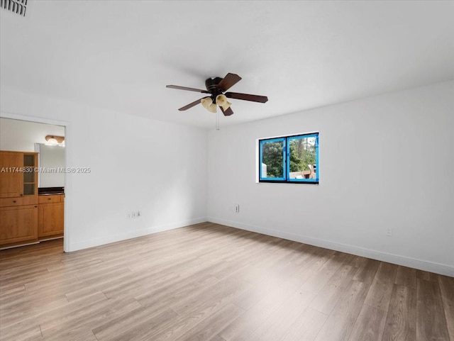 empty room with ceiling fan and light hardwood / wood-style floors