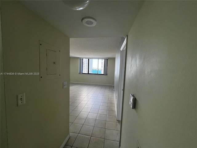 hallway with light tile patterned floors, electric panel, and a textured ceiling