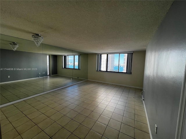 tiled empty room with a textured ceiling