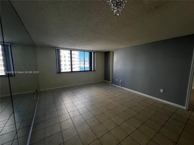 tiled spare room featuring a textured ceiling