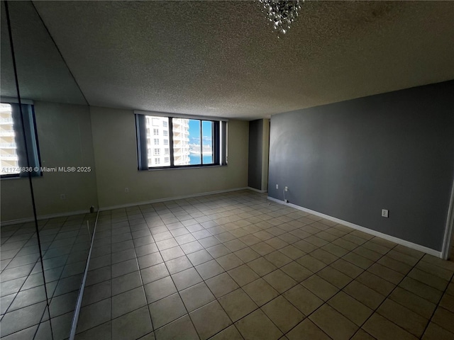 empty room featuring tile patterned flooring and a textured ceiling