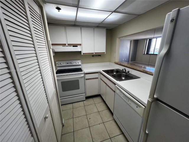 kitchen with sink, light tile patterned floors, white cabinets, and white appliances