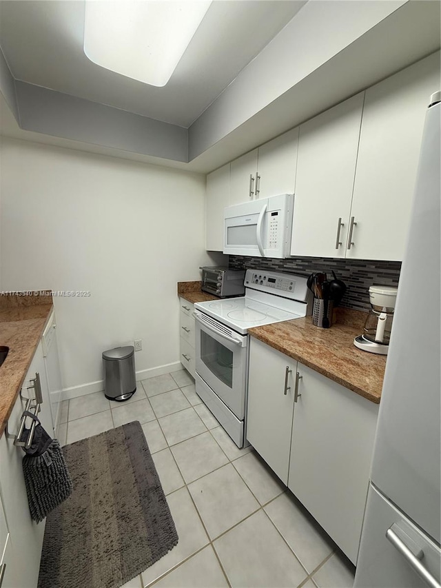 609 Waterside Dr Unit 609, Hypoluxo, FL 33462 - kitchen with white appliances, light tile patterned floors, white cabinetry, light stone counters, and tasteful backsplash