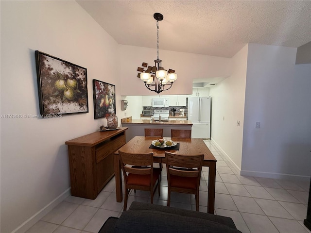 609 Waterside Dr Unit 609, Hypoluxo, FL 33462 - dining area with a chandelier, light tile patterned floors, and a textured ceiling