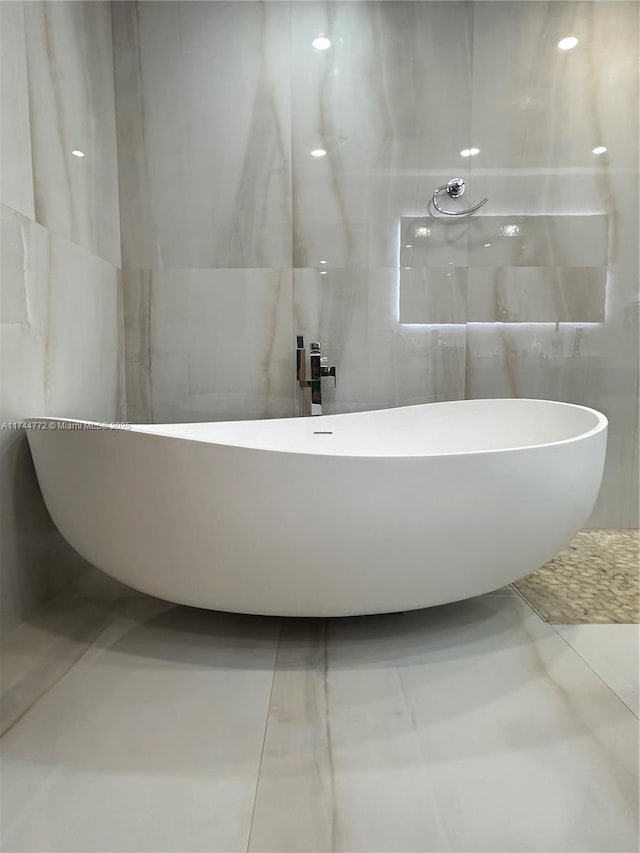 bathroom with tile walls and a tub