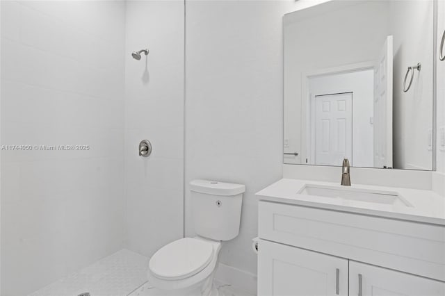 bathroom featuring vanity, toilet, and tiled shower