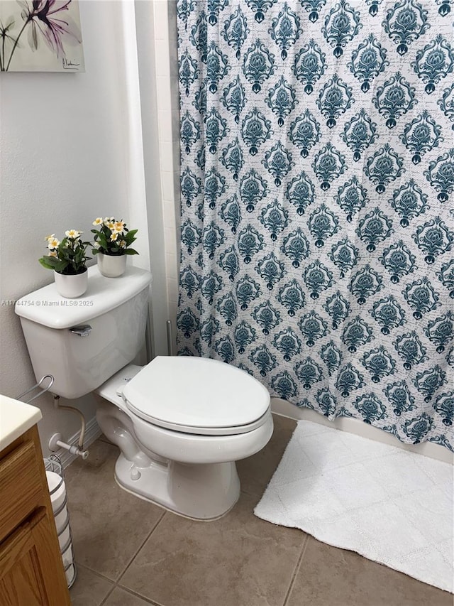 bathroom featuring vanity, walk in shower, tile patterned floors, and toilet