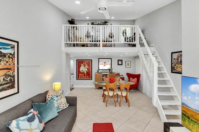 living room featuring ceiling fan, a towering ceiling, and light tile patterned floors