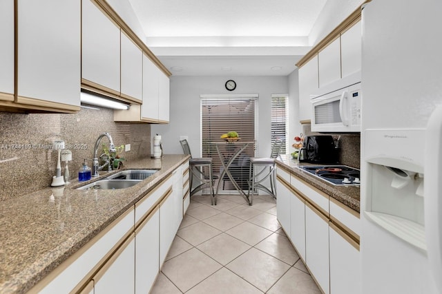 kitchen featuring sink, light tile patterned floors, white appliances, decorative backsplash, and white cabinets