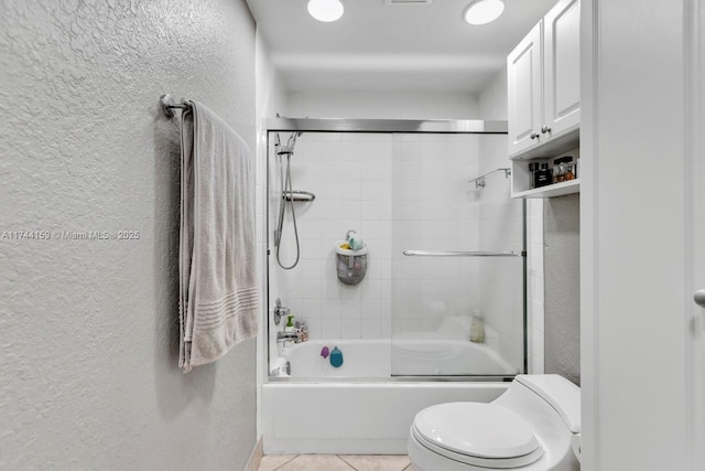 bathroom featuring enclosed tub / shower combo, tile patterned floors, and toilet