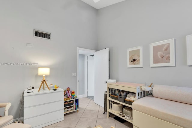 bedroom with a towering ceiling and light tile patterned floors