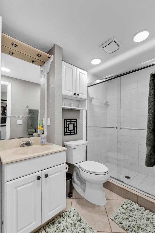 bathroom featuring vanity, toilet, an enclosed shower, and tile patterned flooring