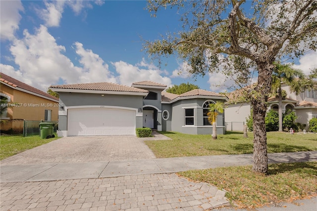 mediterranean / spanish-style home with a front lawn and a garage