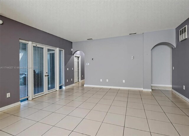 2120 SE 17th Ave, Homestead, FL 33035 - spare room with a textured ceiling, arched walkways, french doors, and light tile patterned flooring