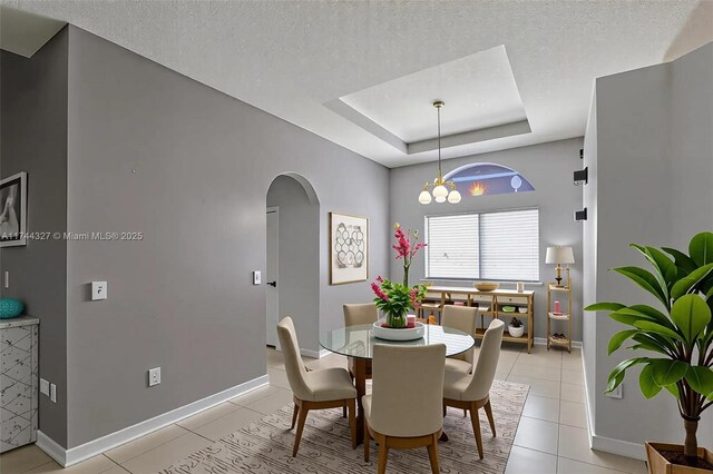 2120 SE 17th Ave, Homestead, FL 33035 - dining area with arched walkways, light tile patterned flooring, a raised ceiling, and a textured ceiling